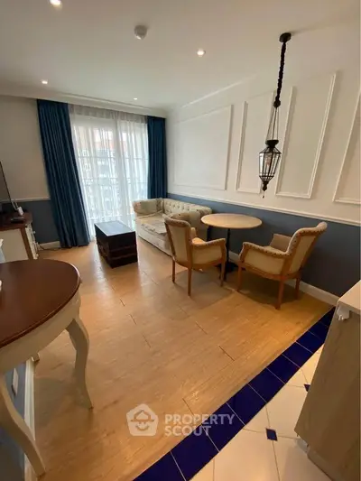 Charming living room with elegant decor and natural light, featuring stylish furniture and wooden flooring.