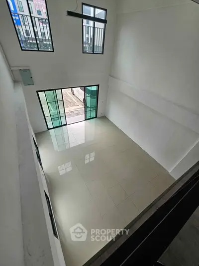 Spacious modern living room with high ceilings and large windows for natural light.