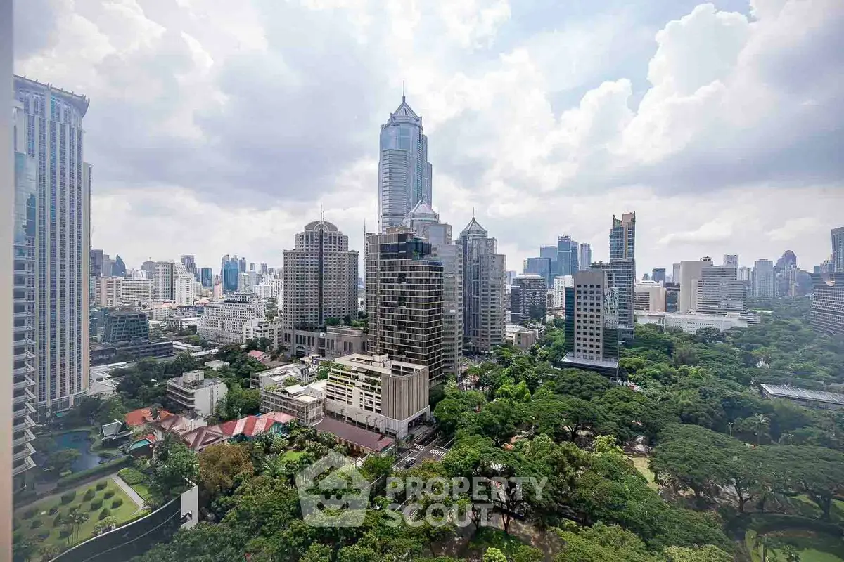 Stunning cityscape view with lush greenery and modern skyscrapers under a cloudy sky.
