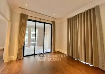 Spacious living room with elegant curtains and balcony access in modern apartment.
