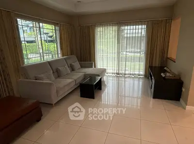 Spacious living room with modern sofa and large windows offering natural light.