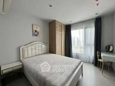 Modern bedroom with elegant decor and city view, featuring a stylish bed and ample natural light.