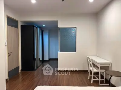 Modern minimalist bedroom with sleek wooden flooring and stylish furniture