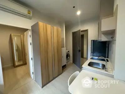 Modern compact kitchen with washing machine and sleek wooden cabinets