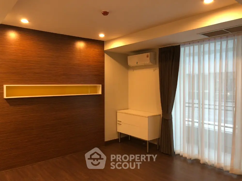 Modern living room with wooden flooring and air conditioning, featuring elegant curtains and ambient lighting.