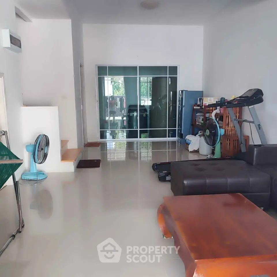 Spacious living room with modern furniture and exercise equipment, ideal for comfortable living.