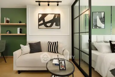 Modern living room with stylish decor and adjacent bedroom separated by glass partition.