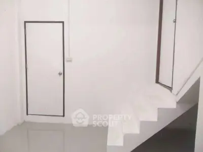 Minimalist interior with white staircase and door, perfect for modern living spaces.