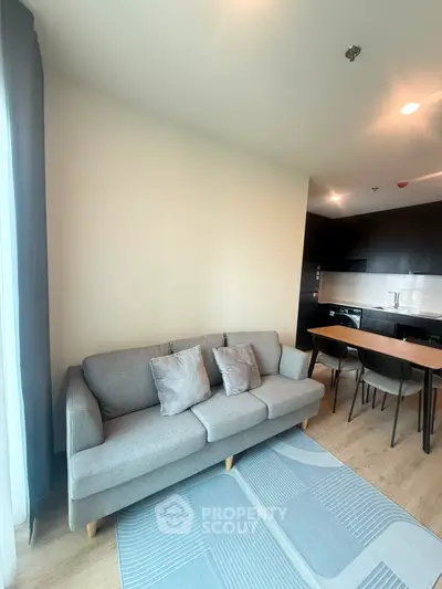 Modern living room with cozy sofa and open kitchen layout in a stylish apartment.