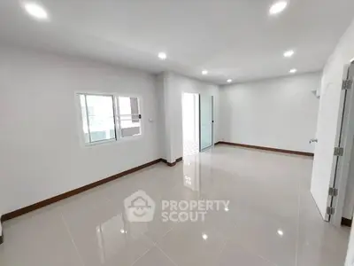 Spacious empty room with glossy tiled floors and bright lighting