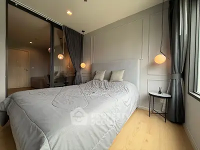 Modern bedroom with elegant decor and large window offering natural light.