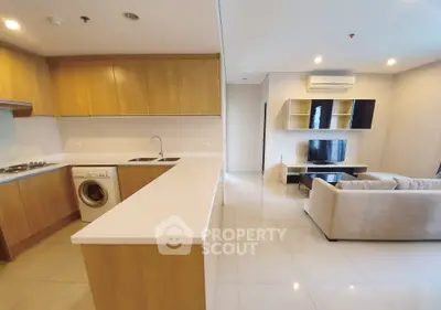 Modern open-plan living room and kitchen with sleek design and neutral tones.