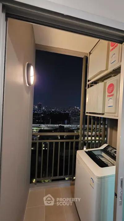 Chic urban balcony with city skyline view and modern washing machine setup.