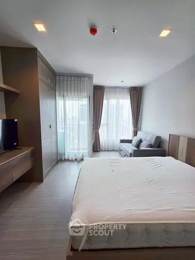 Spacious modern bedroom with large windows and stylish furnishings