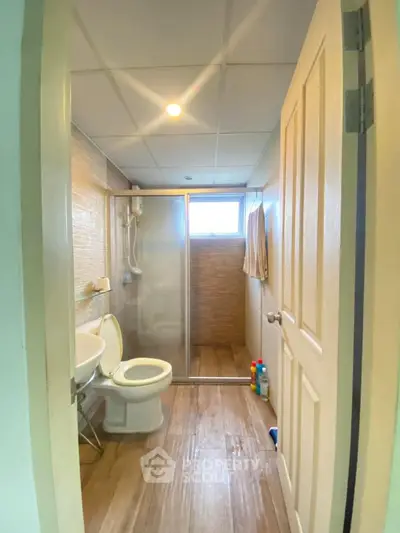 Modern bathroom with glass shower and wooden flooring