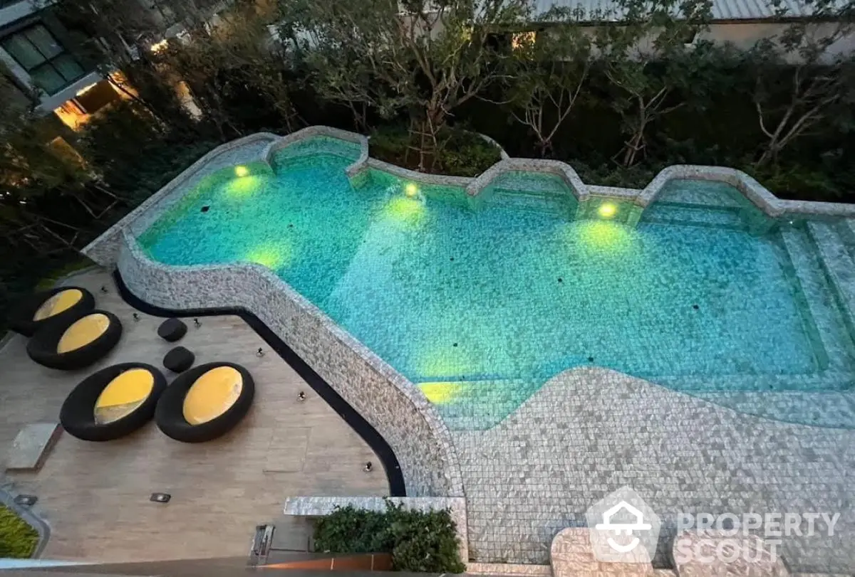 Luxurious outdoor pool with elegant design and ambient lighting in a serene garden setting.