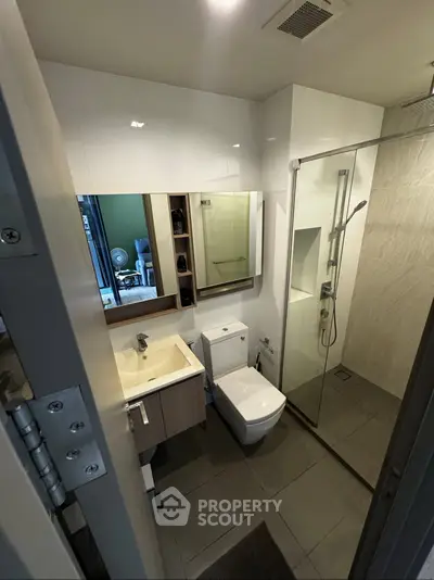 Modern bathroom with glass shower and sleek fixtures in a contemporary apartment.
