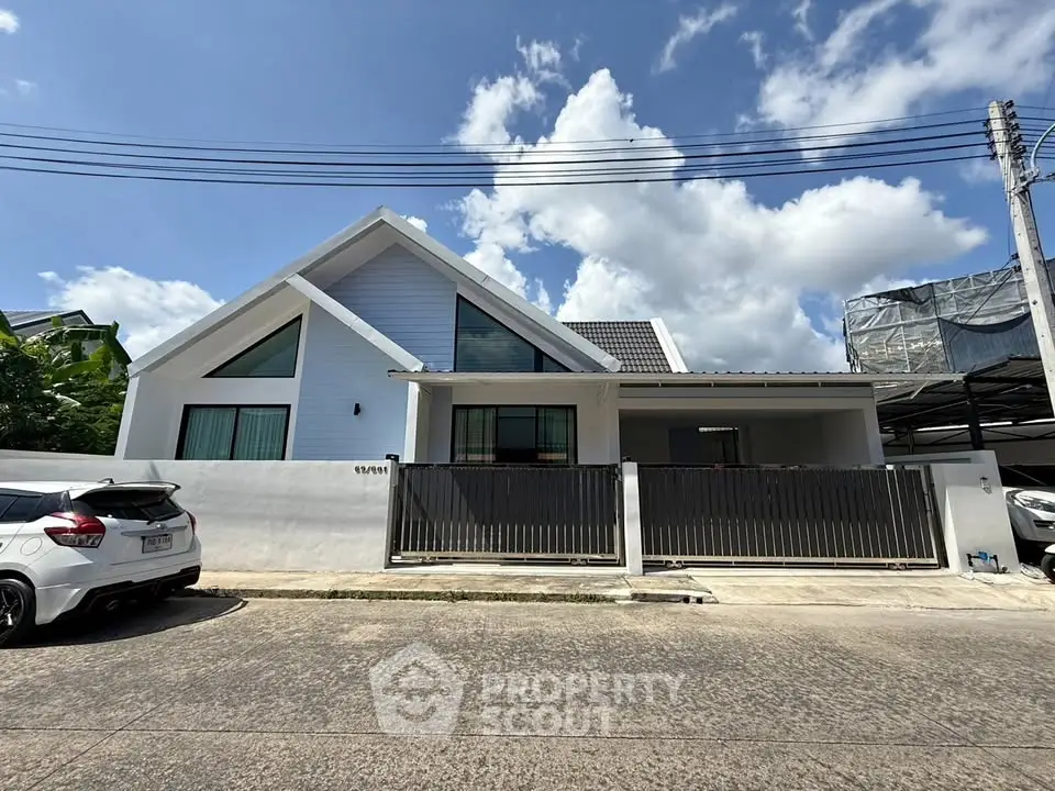 Modern single-story house with sleek design and spacious driveway under a clear blue sky.