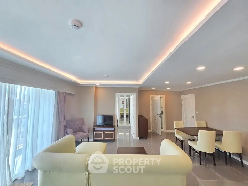 Spacious modern living room with elegant lighting and comfortable seating in a luxury apartment.