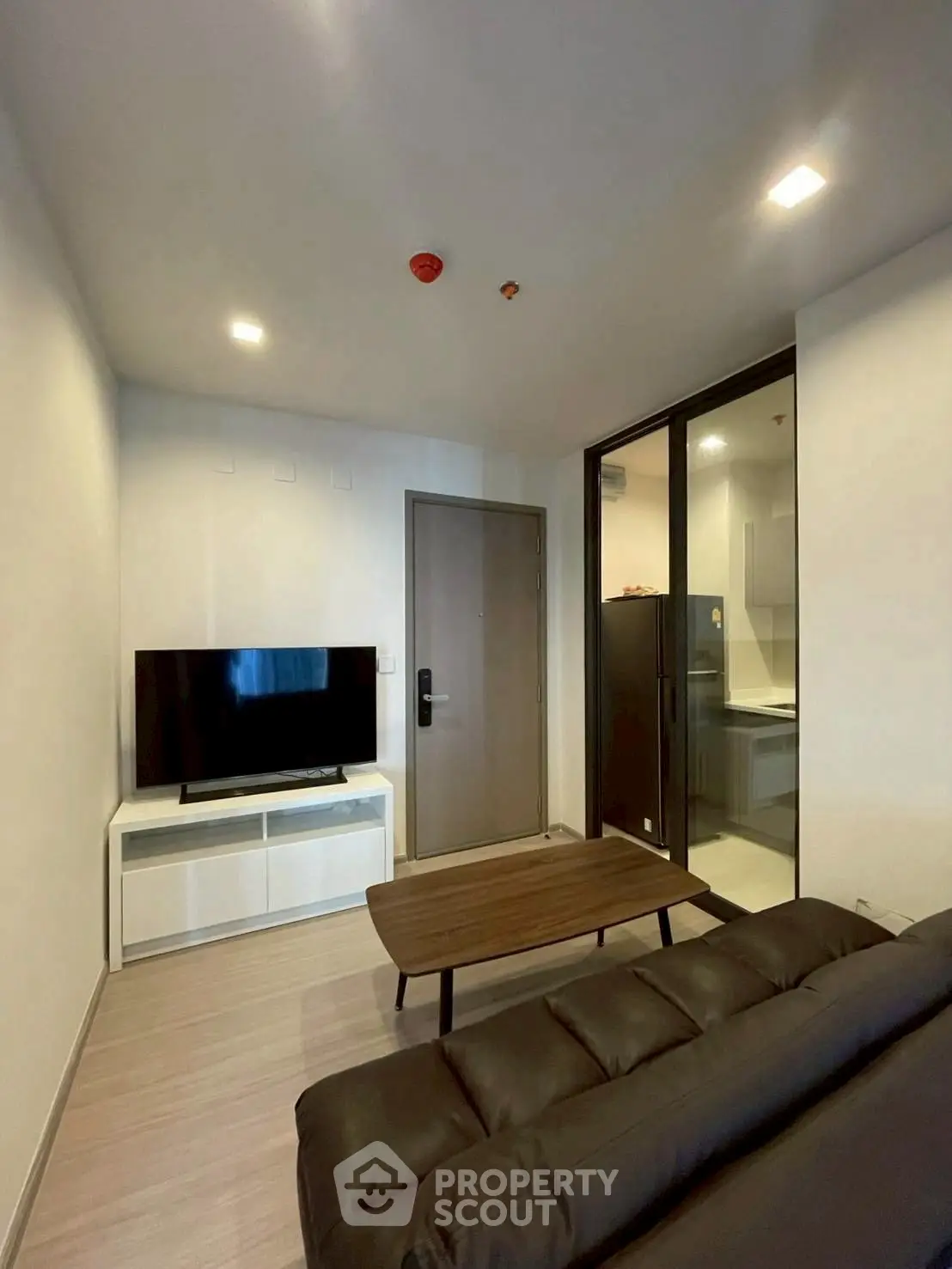 Modern living room with sleek furniture and open kitchen layout in a stylish apartment.