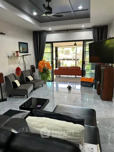 Luxurious living room with modern decor and large windows opening to a garden view.