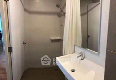 Modern bathroom with sleek sink and shower area, ideal for contemporary living.
