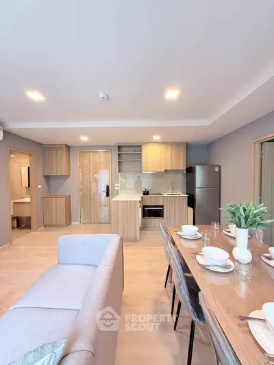 Modern open-plan living room and kitchen with elegant dining area and stylish decor.