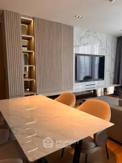 Modern living room with marble table and built-in TV unit, elegant design.