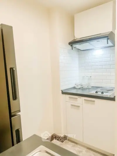 Compact modern kitchen with sleek appliances and stylish backsplash