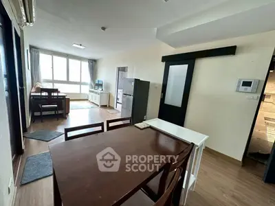 Spacious open-plan living and dining area with modern furnishings and large windows.