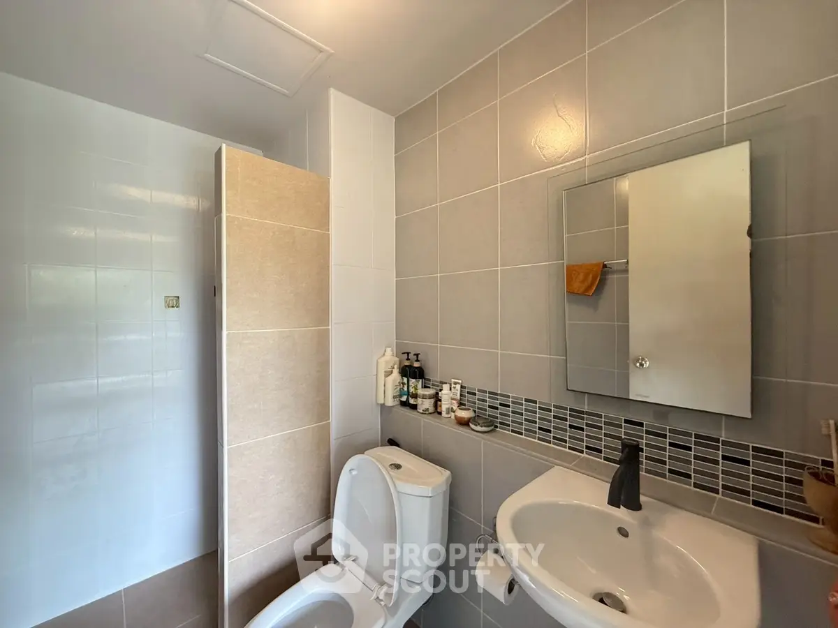Modern bathroom with sleek fixtures and neutral tile design.