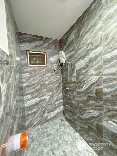 Modern bathroom with stylish marble tiles and shower unit