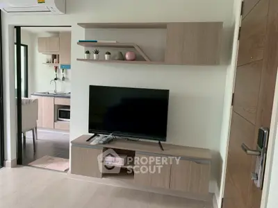 Modern living room with sleek TV unit and open kitchen view, perfect for cozy urban living.