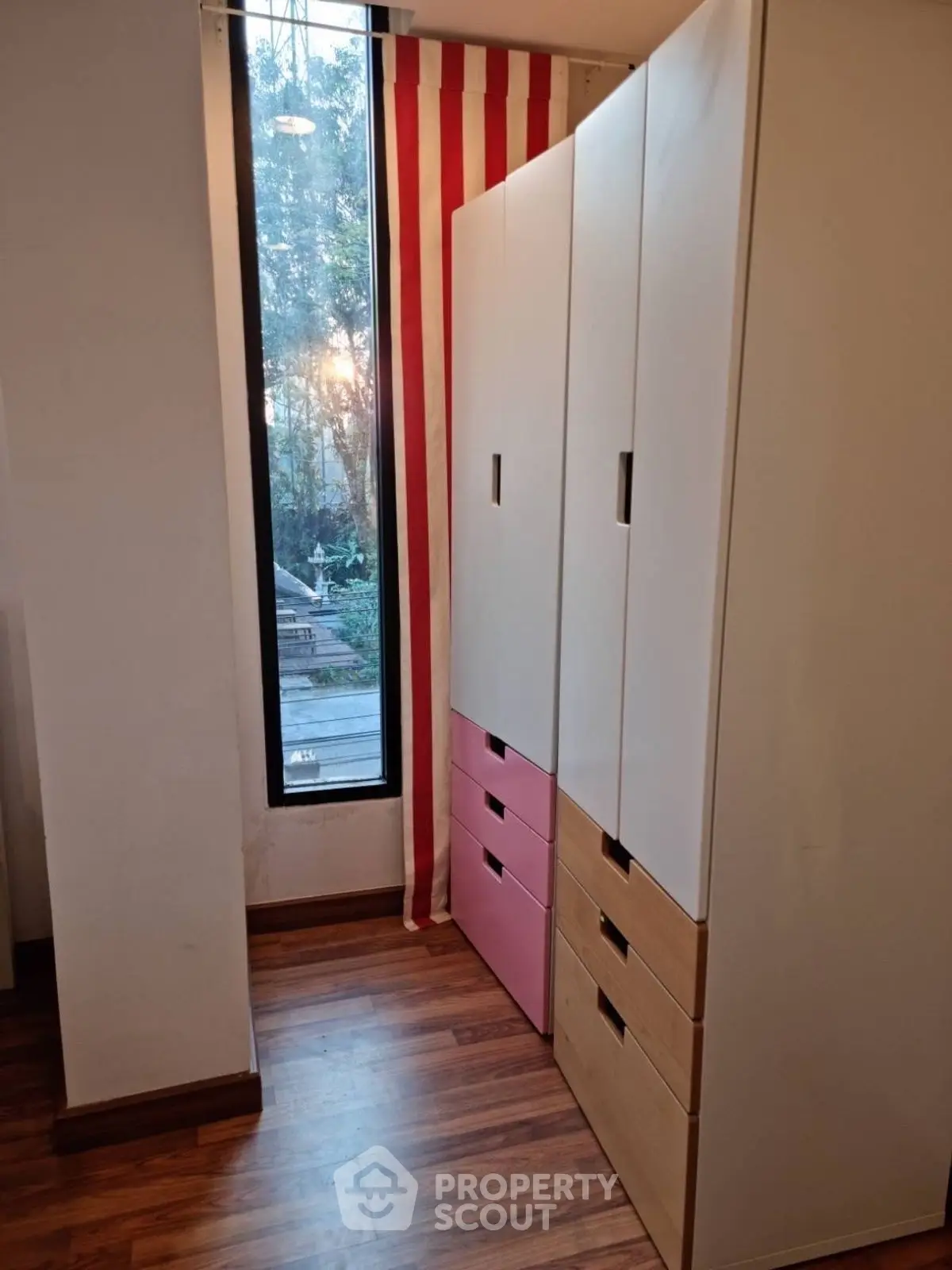 Cozy interior with modern wardrobe and large window overlooking garden