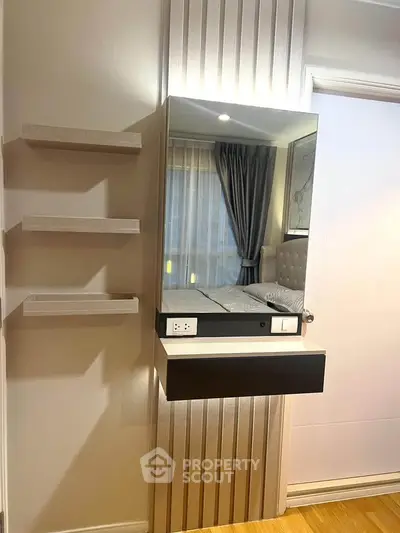 Modern bedroom with stylish mirror and shelves, featuring elegant decor and natural light.