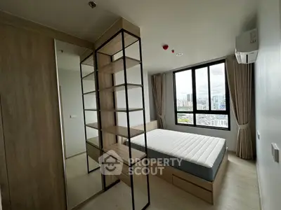 Modern bedroom with large window and built-in storage offering city views
