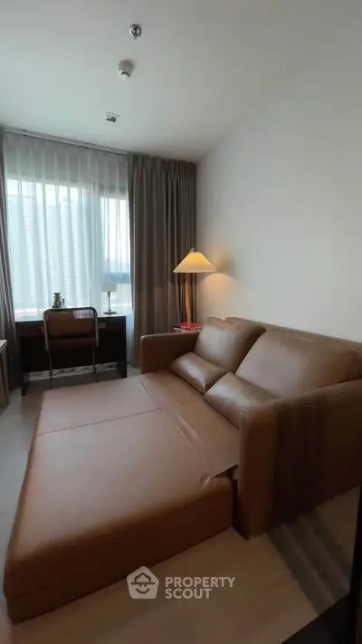 Modern living room with brown leather sofa bed and large window view.