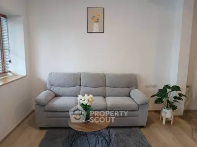 Cozy living room with a plush gray sofa, wooden coffee table, and elegant decor accents.
