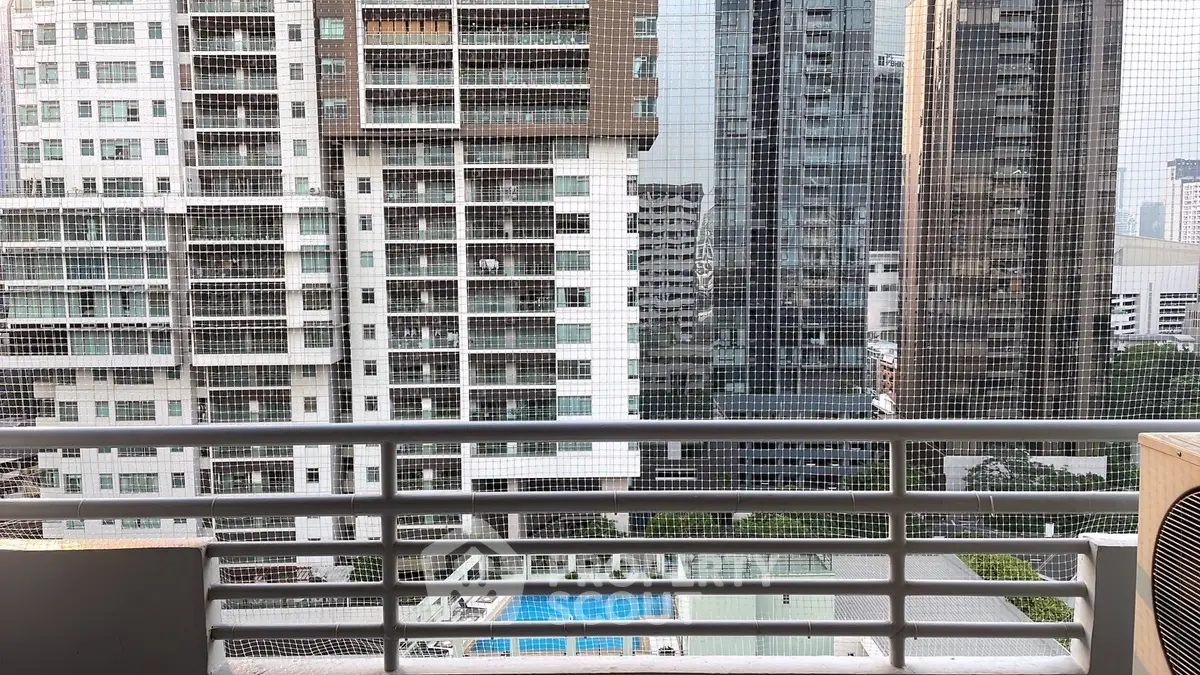 High-rise city view from a balcony with pool and modern architecture.