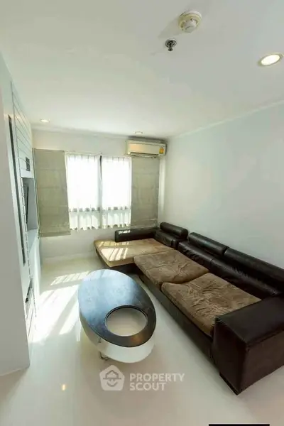 Modern living room with sleek leather sofa and natural light