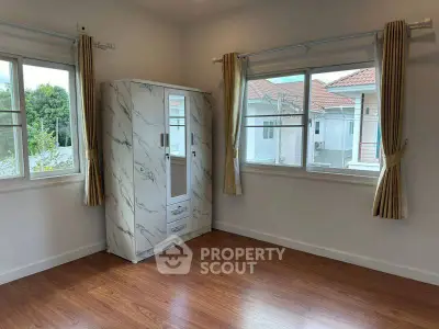 Bright empty room with large windows and wooden flooring in modern home