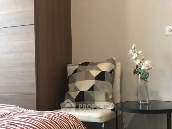 Cozy bedroom corner with modern decor and geometric cushion