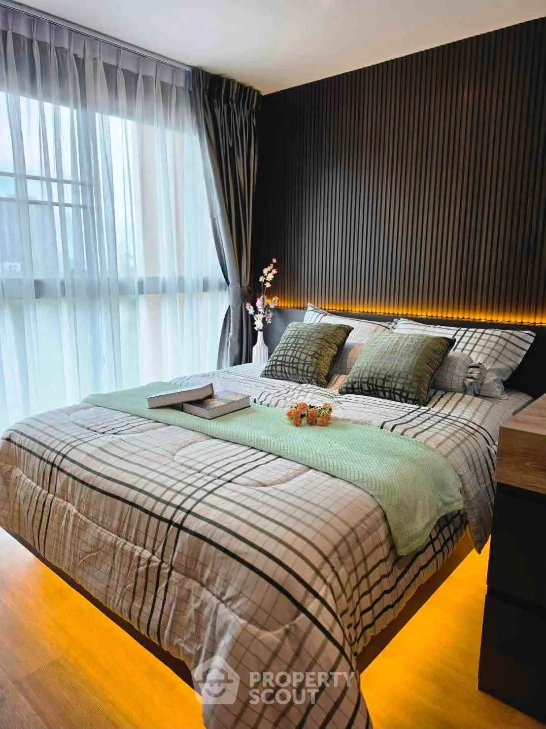 Modern bedroom with stylish lighting and large window, perfect for relaxation and comfort.
