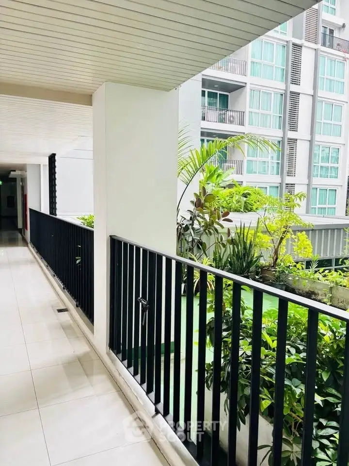 Modern apartment building corridor with lush greenery and sleek design