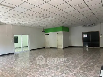 Spacious open-plan room with tiled flooring and modern ceiling design