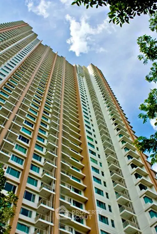Stunning high-rise building with modern architecture and expansive balconies against a clear blue sky.