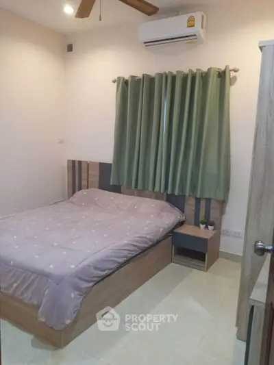 Cozy bedroom with modern furnishings and air conditioning, perfect for comfortable living.