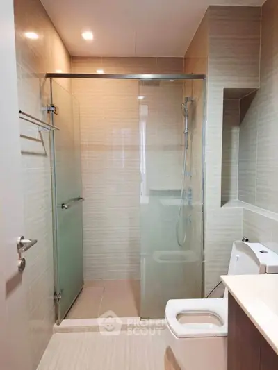 Modern bathroom with glass shower enclosure and sleek fixtures.