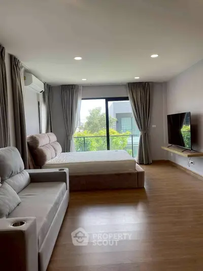 Spacious modern bedroom with large window and stylish furnishings