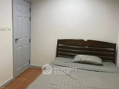 Cozy bedroom with wooden bed frame and neutral decor